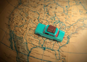 Toy car with luggage on a vintage globe map