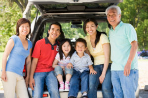Extended family sitting in tailgate of car