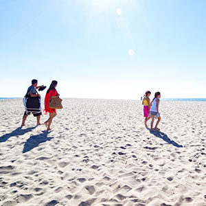 family of four walking on sand at Oxnard Beach