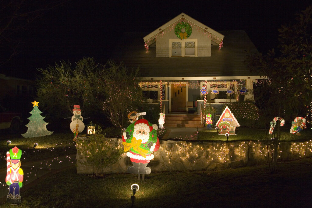 Santa Claus waving in front of house with Christmas lights in Oxnard, California