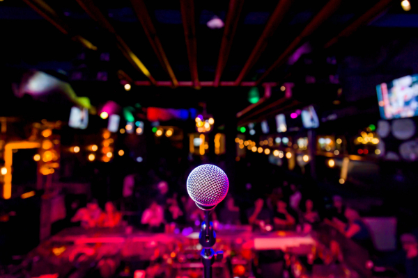 Levity comedy club microphone on stage with crowd of people in the background