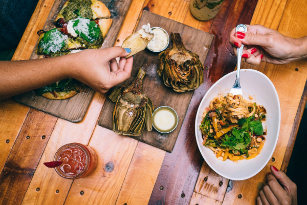 dining table with plates of food and people eating